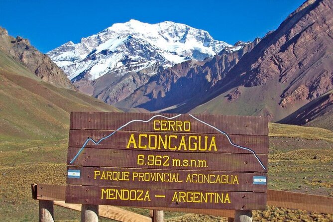 Cartel del Cerro Aconcagua 6962 msnm con la montaña nevada de fondo