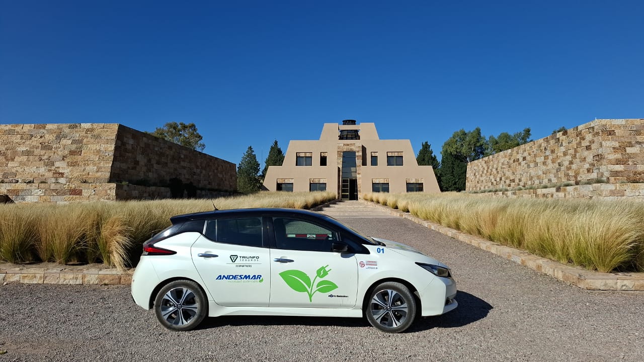 Nissan Leaf eléctrico blanco de Lila Eco Tours frente a una bodega en Mendoza